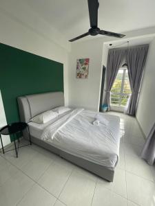 a bedroom with a large bed with a green headboard at V Cozy Homestays in Brinchang