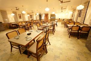 a dining room with tables and chairs and lights at Anaasa Resorts in Tiruvannāmalai
