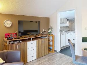 a living room with a desk with a tv and a kitchen at Apartment Petra by Interhome in Grafenwiesen