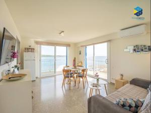 a living room with a couch and a table with chairs at Apartamento Rocamar in S'Illot