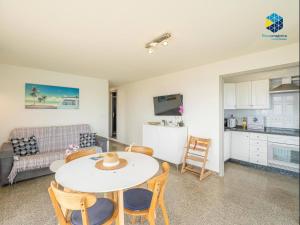 a kitchen and a living room with a table and chairs at Apartamento Rocamar in S'Illot +17 photos