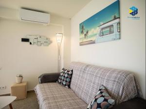 a living room with a couch and a picture of a caravan at Apartamento Rocamar in S'Illot
