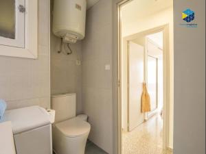 a bathroom with a white toilet and a mirror at Apartamento Rocamar in S'Illot