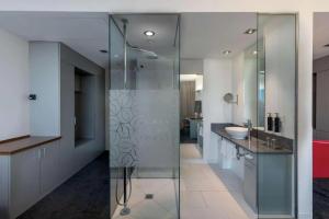 a bathroom with a glass shower and a sink at Windmill Frankfurt Niederrad in Frankfurt