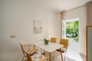 a white dining room with a white table and chairs at Ferienwohnung Seestern in zentraler Lage von Eckernförde in Eckernförde