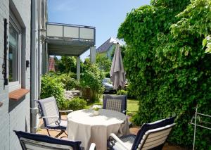 a patio with a table and chairs and an umbrella at Ferienwohnung Seestern in zentraler Lage von Eckernförde in Eckernförde