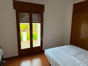 a bedroom with a bed and a large window at Masia Garridells in L'Ampolla