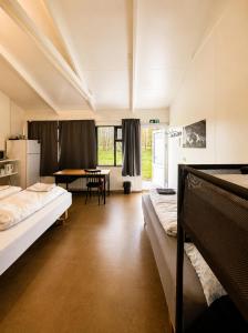 a large room with two beds and a table at Arhus Cottage and Camping in Hella