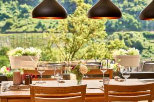 a table with chairs and wine glasses in a restaurant at Wohnen am Weingut - Bei den Weinbergen in Briedel