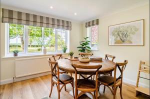 a dining room with a wooden table and chairs at Dalforth Thaxted Barn Collection in London Stansted Airport