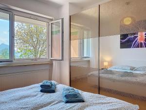 a bedroom with two pairs of towels on a bed at Apartment Apt-Woka by Interhome in Aldesago