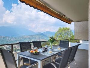 a table with a bowl of fruit on top of a balcony at Apartment Apt-Woka by Interhome in Aldesago