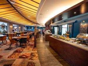 a restaurant with tables and chairs and a buffet at Mercure Mont Saint Michel in Le Mont Saint Michel