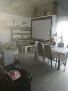 a living room with a table and chairs and a screen at Christophe in Crest