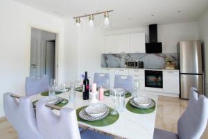 a dining room with a table and chairs and a kitchen at Vacation apartments Mario with salt water pool in Turjaci +70 photos