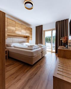a bedroom with a large bed and a large window at Grmovškov dom Kope in Mislinja