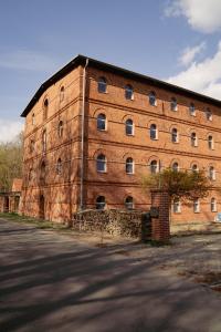 a large red brick building with many windows at Motel Q Kornspeicher in Neuruppin