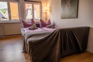 a bed with purple pillows on it in a room at Goslar LIVING 1 - Modern & Zentral in Goslar
