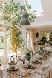 a long dining table with white chairs and a large window at The Hamptons Beach House in East Preston