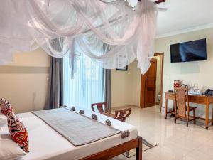 a bedroom with a bed and a dining room at Le Lodge des Almadies in Dakar