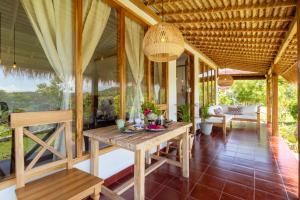 a dining room with a table and chairs on a porch at Breath House Penida in Polilit