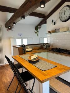a kitchen with a wooden table and a clock on the wall at Alla vigna in Bassano del Grappa