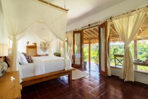a bedroom with a bed and some windows at Breath House Penida in Polilit