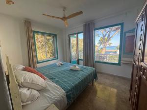 a bedroom with a bed with a fan and two windows at Es Raco de Canyamel in Canyamel