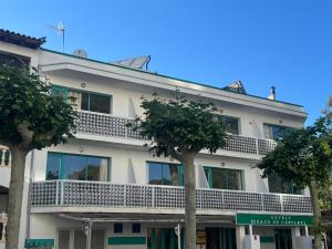a white building with trees in front of it at Es Raco de Canyamel in Canyamel