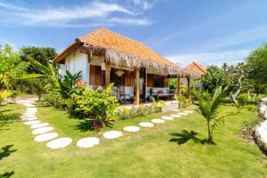 a garden with a house with a pathway leading to it at Breath House Penida in Polilit