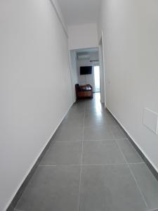 an empty hallway with white walls and a tiled floor at Panorama Palace 2 in Palasë +10 photos