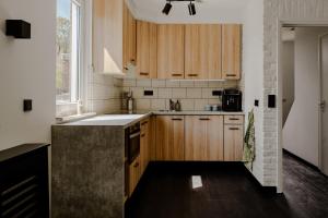 eine Küche mit Holzschränken und einem großen Fenster in der Unterkunft Chefs in Gulpen-Wittem