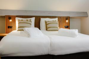 ein großes weißes Bett mit zwei Kissen darauf in der Unterkunft Chefs in Gulpen-Wittem