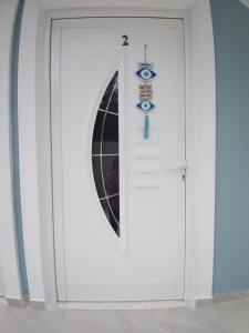 a white door with an eye sign on it at Panorama Palace 2 in Palasë