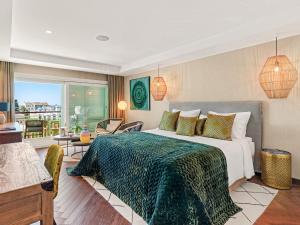a bedroom with a large bed with a green blanket at Boho Club Marbella - a Preferred Hotel in Marbella +84 photos