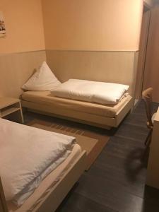 two beds in a room with white sheets at Landgasthof Feihl in Oberwiesenacker