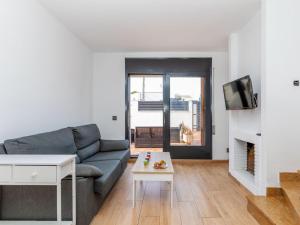 a living room with a couch and a tv at Villa Calas III by Interhome in L'Ametlla de Mar
