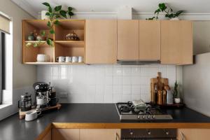 a kitchen with wooden cabinets and a black counter top at Villa 11 Margaret River Beach House in Margaret River Town