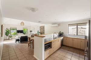an open kitchen and living room with a couch at Villa 11 Margaret River Beach House in Margaret River Town