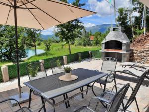 a patio with a table and chairs and a fireplace at Vikendica Dijana Ramsko jezero in Ploča