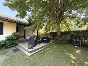 a backyard with a tree and a wooden deck at Au gat in Léon