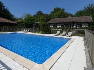 a swimming pool with chairs and a fence at Au gat in Léon
