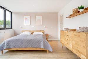 a bedroom with a bed and a wooden dresser at Fischerhus Laboe in Laboe