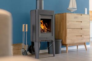 a fireplace with a fire in it next to a dresser at Fischerhus Laboe in Laboe
