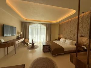 a hotel room with a bed and a desk at Iconic Mediterranean Hotel in Dhërmi +41 photos