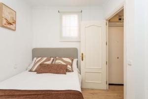 a bedroom with a white bed with a pillow on it at Barbieri III in Madrid