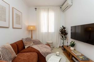 a living room with a couch and a flat screen tv at Barbieri III in Madrid