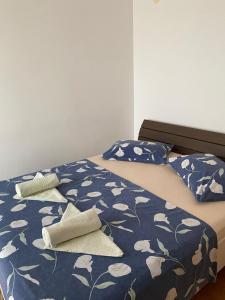 a bed with blue and white sheets and pillows at H&T in Senj