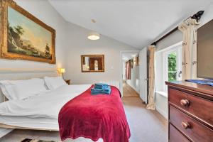 a bedroom with a bed with a red blanket on it at Finest Retreats - The Pottage in Yaxley
