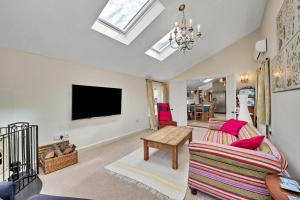 a living room with a couch and a flat screen tv at Finest Retreats - The Pottage in Yaxley